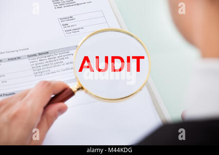 Portrait of businessman examining vérification avec loupe in office Banque D'Images