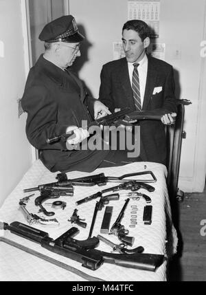 Courriers de la police d'armes illégales et d'armes après un raid dans la région de Chicago, ca. 1957. Banque D'Images