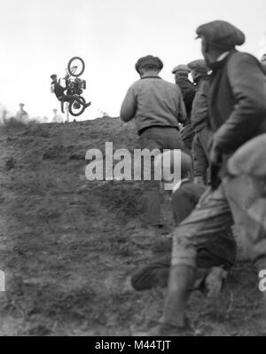 Un motocycliste perd le contrôle de sa moto lors d'une course en montée, ca. 1928. Banque D'Images