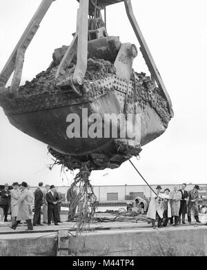 D'affaires et aux leaders de faire semblant d'aider l'équipement lourd au cours d'un à un site de développement, ca. 1961. Banque D'Images