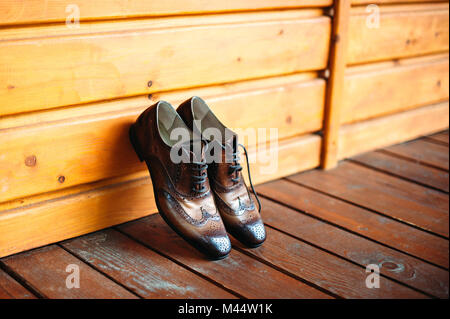 Chaussures homme en cuir marron, près de mur en bois. Homme casual vintage accessoires. Banque D'Images