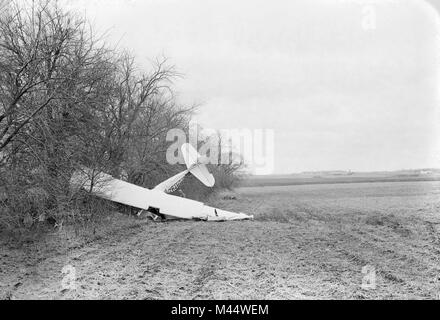 Un seul moteur avion est niché à une ligne d'arbres après un crash dans un champ de la ferme de l'Illinois, ca. Banque D'Images