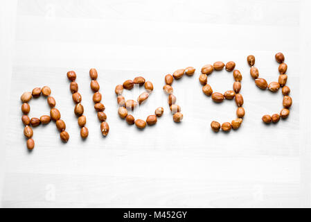 Écrit avec l'arachide. allergie Word et Texte fabriqué à partir d'écrous. L'arachide sur table en bois blanc ou du conseil. Réaction allergique et problème de nutrition concept Banque D'Images