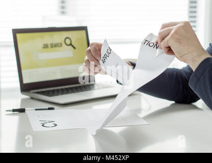 L'extraction de l'homme papier de demande d'emploi. Personne ayant des difficultés à écrire son CV ou trouver du travail. En colère, frustré et fatigué d'être rejeté. La dépression. Banque D'Images