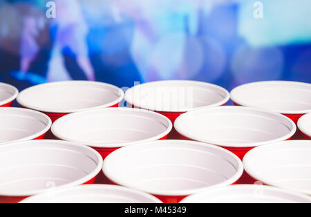 De nombreux parti rouge tasses avec troubles de rendre hommage aux personnes à l'arrière-plan. Low angle close up of college les contenants d'alcool. Le marketing et la promotion. Banque D'Images