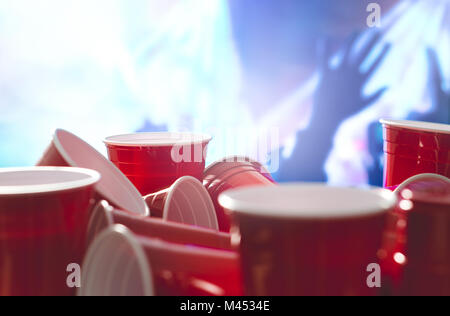 De nombreux parti rouge tasses avec troubles de rendre hommage aux personnes à l'arrière-plan. College les contenants d'alcool dans des positions mixtes. Banque D'Images