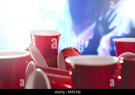 De nombreux parti rouge tasses avec troubles de rendre hommage aux personnes à l'arrière-plan. College les contenants d'alcool dans des positions mixtes. Banque D'Images