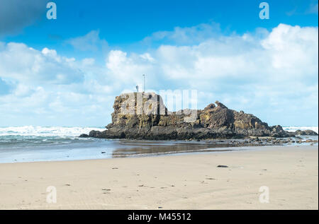 Une silhouette se tenant au-dessus de Chapelle Rocher sur Broad Oak Beach, à Cornwall. Banque D'Images