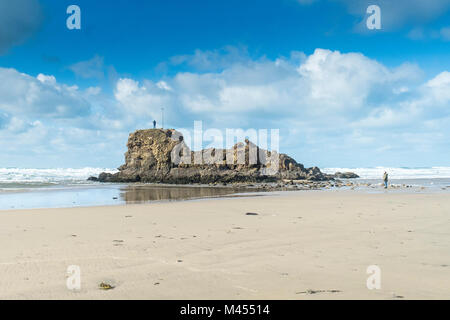 Une silhouette se tenant au-dessus de Chapelle Rocher sur Broad Oak Beach Cornwall UK. Banque D'Images