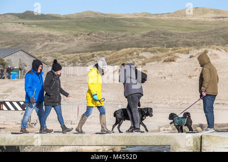 Les gens promènent leurs chiens sur un petit pont en pierre sur Broad Oak Beach à Cornwall UK. Banque D'Images