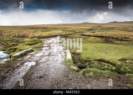 Une piste boueuse sur un petit pont de pierre sur un ruisseau à Rough Tor sur Bodmin Moor en Cornouailles. Banque D'Images