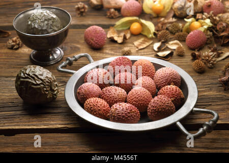 Les litchis, fruits tropicaux sur un plateau d'étain, sur de vieux panneaux en bois Banque D'Images