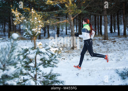 Image de jeunes femmes athlètes qui traverse la forêt d'hiver au cours de jour Banque D'Images