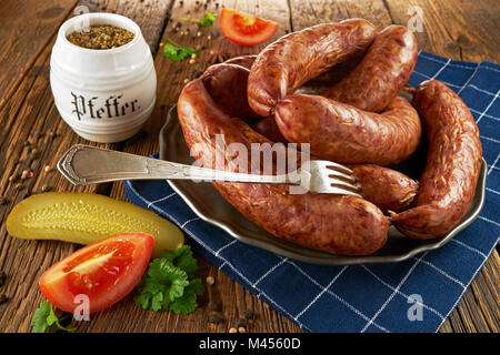 Saucisse polonaise traditionnelle sur un plateau de métal sur de vieilles planches en bois Banque D'Images