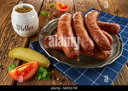 Saucisse polonaise traditionnelle sur un plateau de métal sur de vieilles planches en bois Banque D'Images