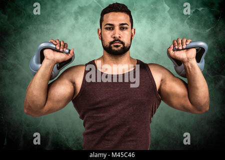 Image composite de l'homme graves musculaire kettlebells de levage Banque D'Images