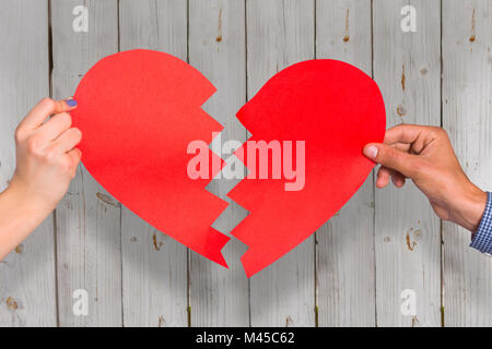 Image composite de deux mains tenant cœur brisé Banque D'Images