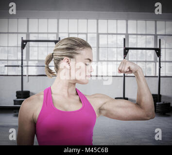 Image composite de la section intermédiaire de muscle woman flexing muscles Banque D'Images