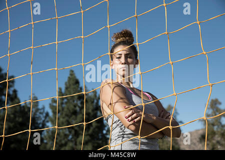 Portrait de femme derrière un filet football but looking at camera Banque D'Images