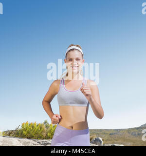 Image composite de jogging happy blonde sportive Banque D'Images