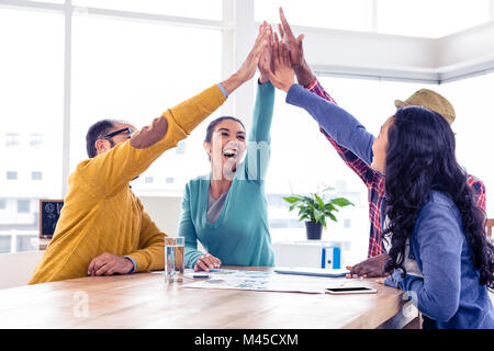 Faire de l'équipe entreprises gaies dans cinq haut creative office Banque D'Images