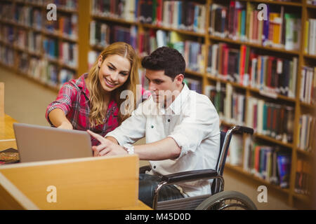 En étudiant avec un camarade de travail en fauteuil roulant Banque D'Images