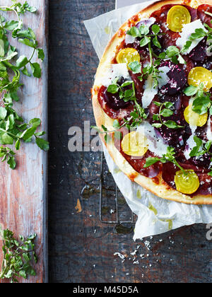 Pizza fraîche avec de la salade et des feuilles de betterave, overhead view Banque D'Images