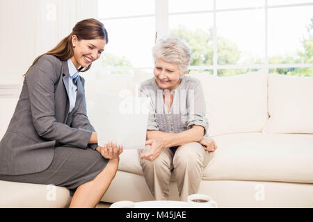 Smiling businesswoman showing documents à senior woman Banque D'Images