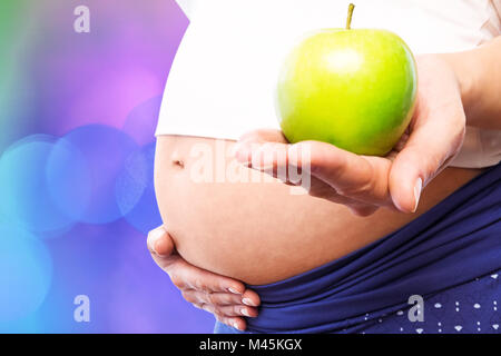 Image composite de pregnant woman holding green apple Banque D'Images