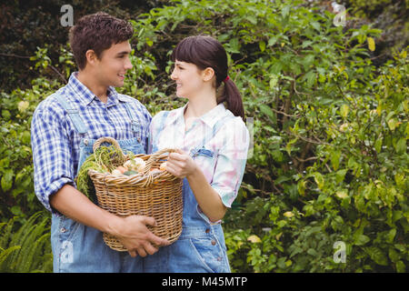 Young couple holding un panier de légumes fraîchement récoltés Banque D'Images