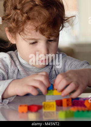 Caucasian girl bâtiment avec des briques lego couleur Banque D'Images
