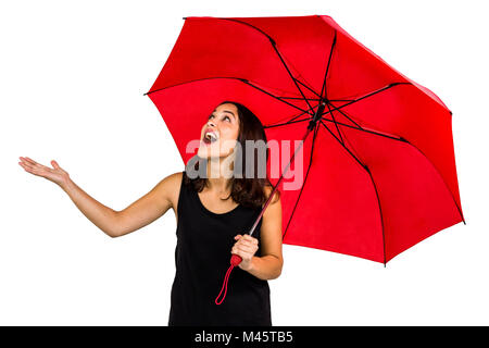 Choqué à la femme tout en maintenant le parapluie rouge Banque D'Images