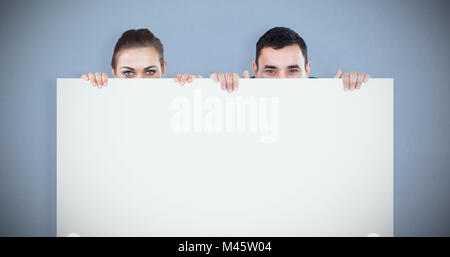 Image composite de partenaires d'affaires de se cacher derrière un signe Banque D'Images