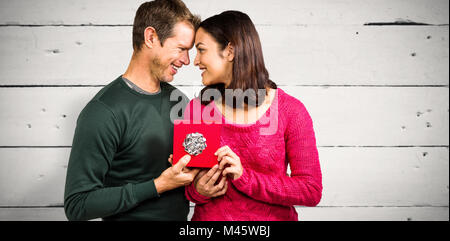Image composite de l'heureux couple holding gift box Banque D'Images
