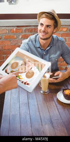 Image composite de waitress beau hipsters commande avec tablet Banque D'Images