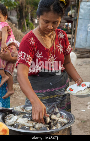 Woman eating et cuisiner les poissons à Bagan Myanmar Banque D'Images