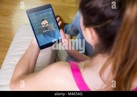 Composite image of woman using tablet at home Banque D'Images