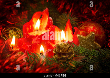 Quatre bougies rouges avec boule de noël et de décoration. Banque D'Images