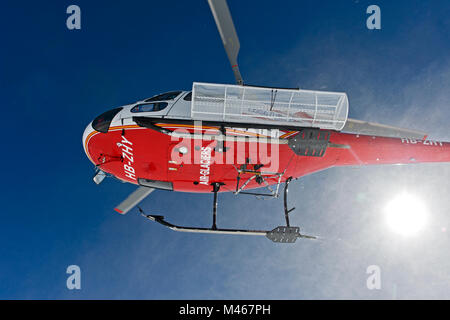 L'héliski, Air Glaciers Hélicoptère Eurocopter AS 350B3 Ecureuil décoller après avoir laissé tomber les skieurs sur le pic de Äbeni Flue, Berness Alpes, Suisse Banque D'Images