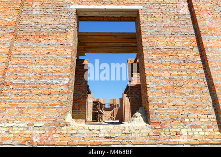 Construction d'une maison de brique. vu par les fenêtres de l'intérieur du bâtiment Banque D'Images