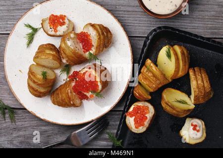 De pommes de terre fraîchement cuits au four avec sauce hollandaise et caviar rouge, vue du dessus Banque D'Images