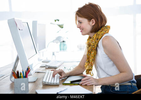 Hipster smiling business woman de taper sur son ordinateur Banque D'Images