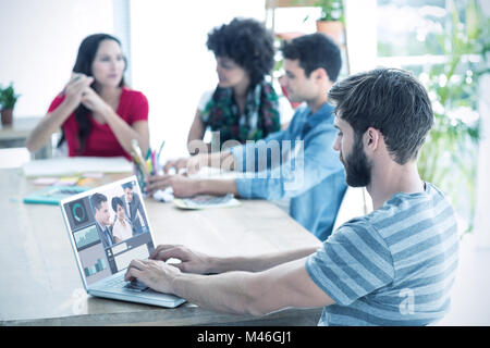 Image composite de businessman tapant sur son ordinateur portable Banque D'Images