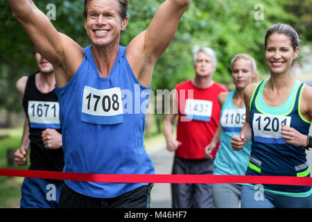 Athlète masculin de marathon de franchir la ligne d'arrivée Banque D'Images