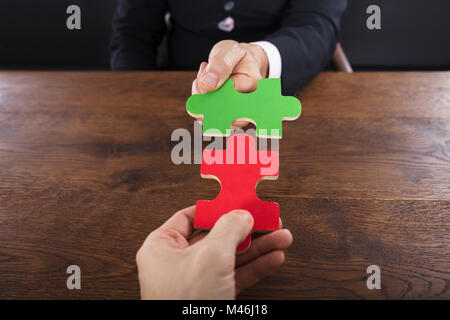 Close-up de deux hommes d'adhérer à des morceaux de puzzle en bois sur 24 Banque D'Images