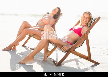 Portrait de deux femmes se détendre sur un fauteuil sur la plage Banque D'Images