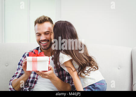 Père holding gift box tout en embrassant sa fille Banque D'Images