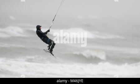 Un kite surfer prend avantage des forts vents dans East Wittering, West Sussex. Banque D'Images