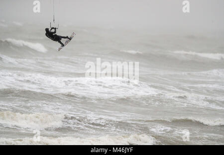 Un kite surfer prend avantage des forts vents dans East Wittering, West Sussex. Banque D'Images