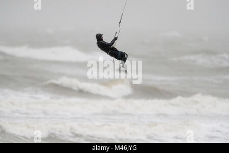 Un kite surfer prend avantage des forts vents dans East Wittering, West Sussex. Banque D'Images